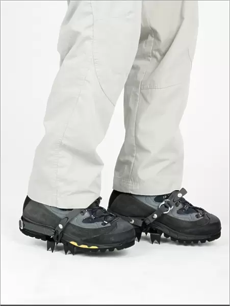 Person wearing boots with crampons, low section