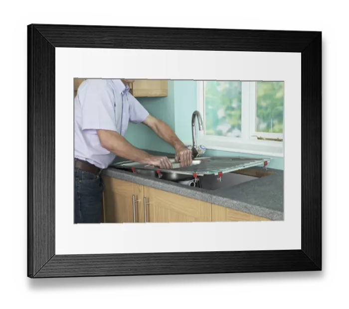 Framed Print : Man placing a new sink in to position in a worktop