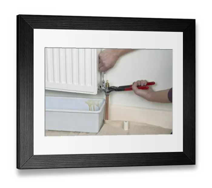 Framed Print : Unlock the bleed valve on a radiator, container underneath radiator Framed Print : Unlock the bleed valve on a radiator, container underneath radiator