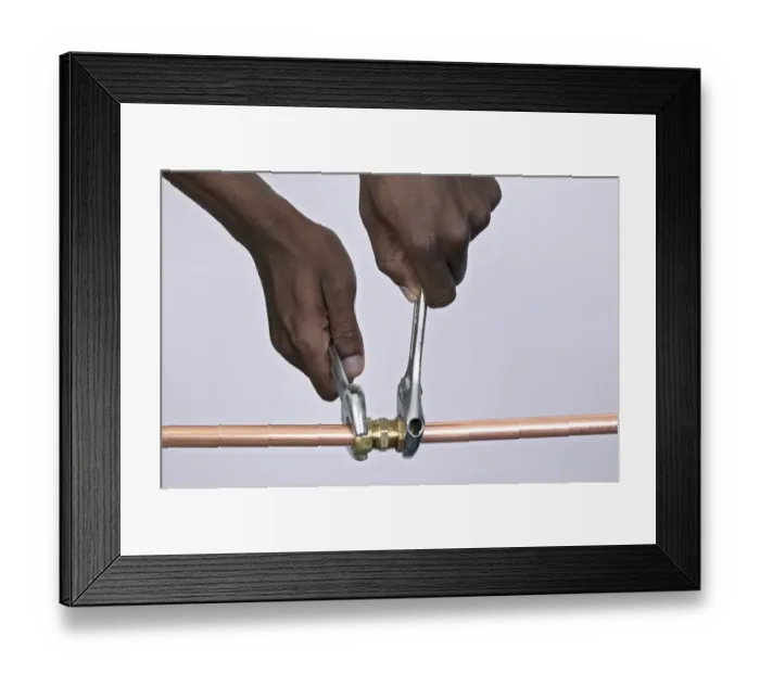 Framed Print : Tightening nuts to a compression joint attached to copper pipes using adjustable spanners Framed Print : Tightening nuts to a compression joint attached to copper pipes using adjustable spanners