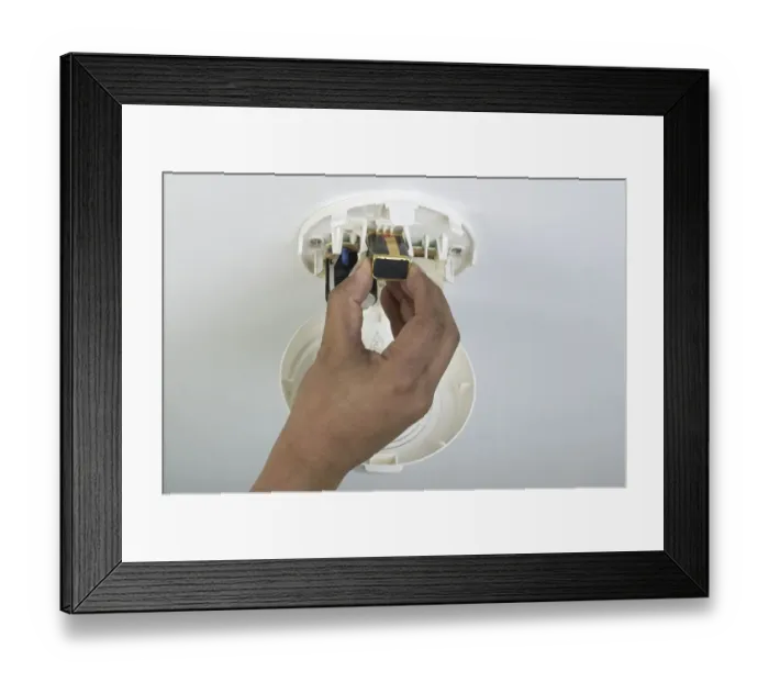Framed Print : Fitting a battery in to a smoke alarm Framed Print : Fitting a battery in to a smoke alarm