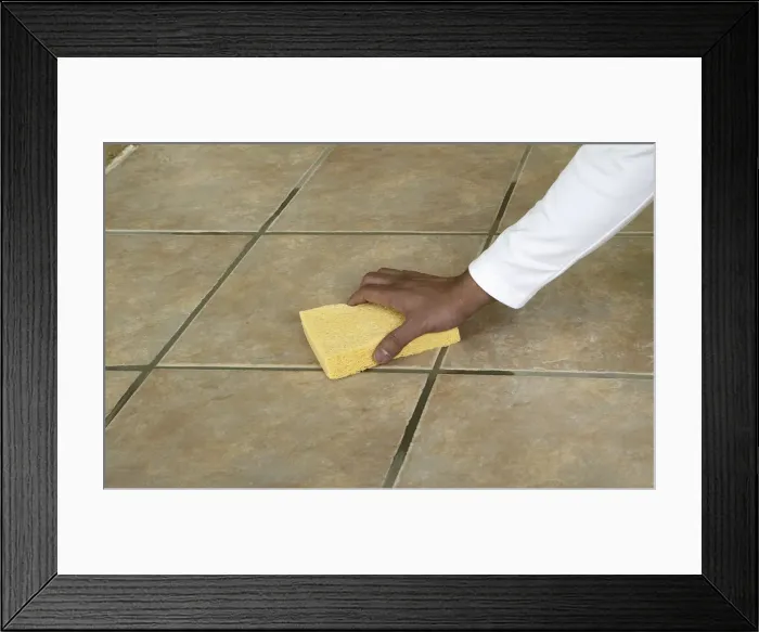 Framed Print : Wiping the surface of a tiled floor with a sponge