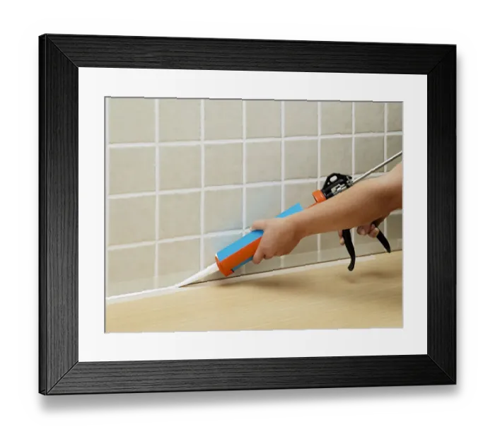 Framed Print : Hands applying sealant to tiles with sealant tube Framed Print : Hands applying sealant to tiles with sealant tube