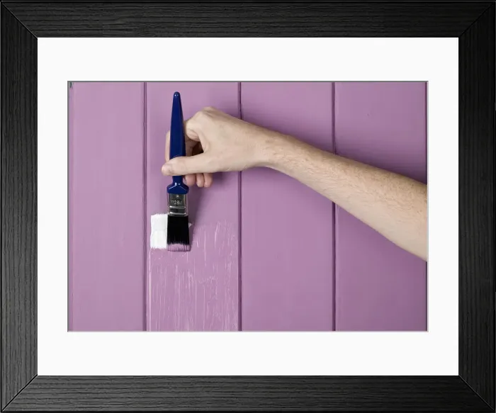 Framed Print : Hand holding brush to wall Framed Print : Hand holding brush to wall