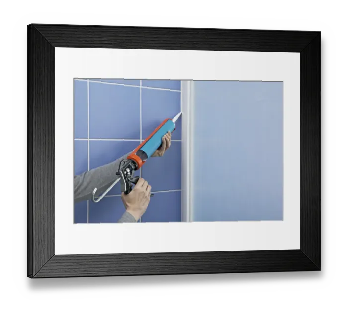 Framed Print : Using a sealant dispenser to seal outside edge of a shower screen Framed Print : Using a sealant dispenser to seal outside edge of a shower screen