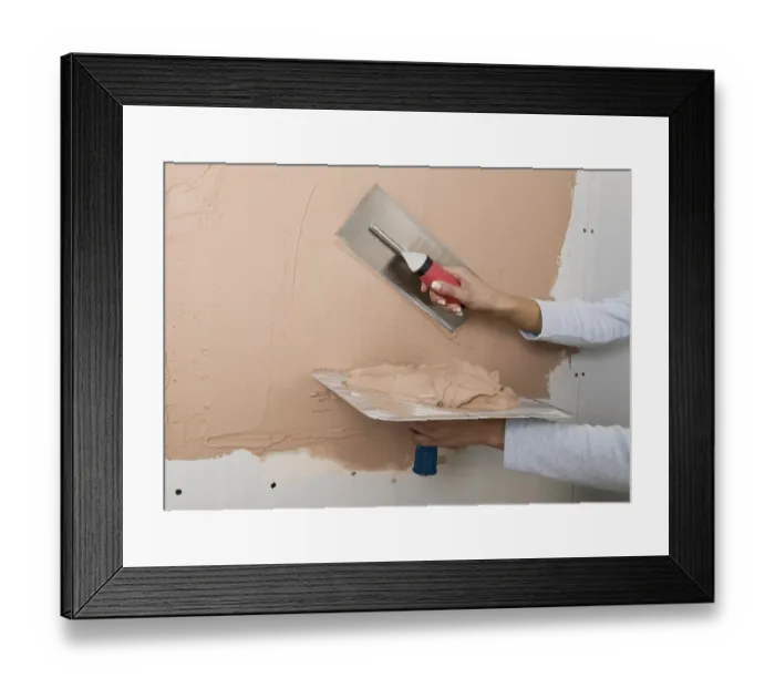 Framed Print : Holding a plastering hawk and spreading plaster onto a wall with a trowel