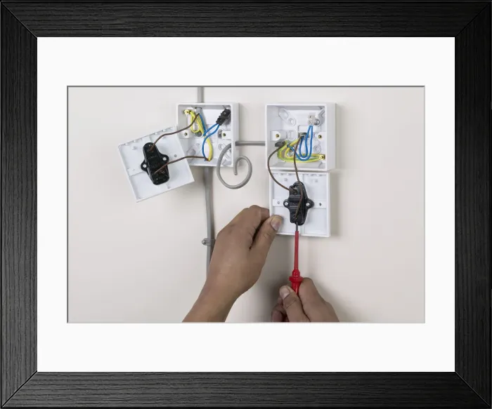 Framed Print : Hands holding screw driver to light switch, face plate off Framed Print : Hands holding screw driver to light switch, face plate off