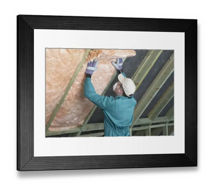 Framed Print : Man wearing overalls, mask, gloves and cap, filling the space between rafters with an insulation blanket Framed Print : Man wearing overalls, mask, gloves and cap, filling the space between rafters with an insulation blanket