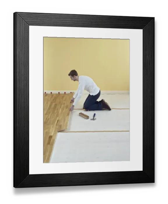 Framed Print : Man kneeling and holding floorboard Framed Print : Man kneeling and holding floorboard