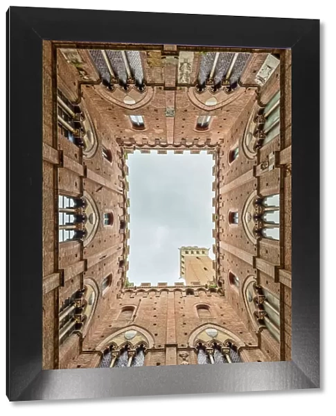 Low angle view of the Torre Del Mangia from Palazzo Pubblico Siena Tuscany
