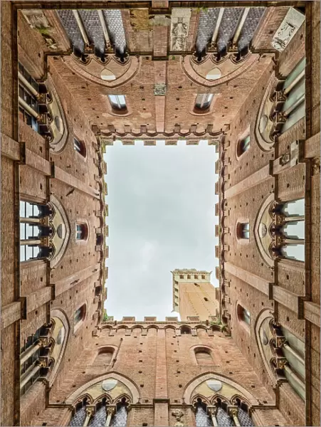 Low angle view of the Torre Del Mangia from Palazzo Pubblico Siena Tuscany