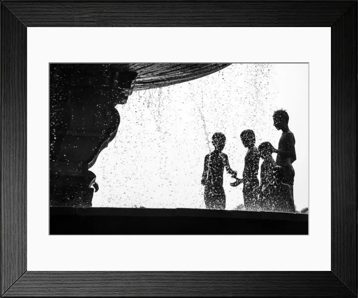 Framed Print : Too Hot. Many boys relax from hot air by water fountain in the Delhis public park Framed Print : Too Hot. Many boys relax from hot air by water fountain in the Delhis public park