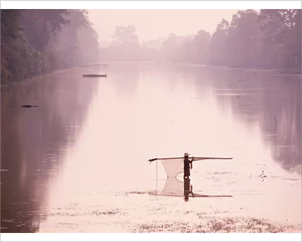 Woman carrying fishing net across river