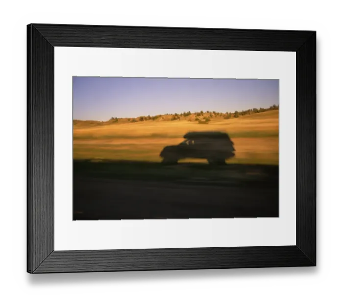 Framed Print : USA, Montana, SUV casting shadow on roadside, sunset (blurred motion)