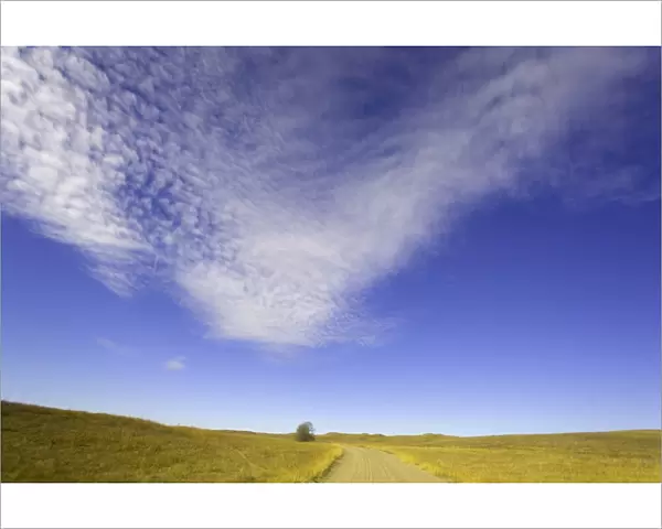 USA, central Nebraska, clouds above gravel ranch road and grassland