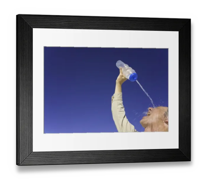 Framed Print : Mature man pouring water over face under clear sky, low angle view Framed Print : Mature man pouring water over face under clear sky, low angle view