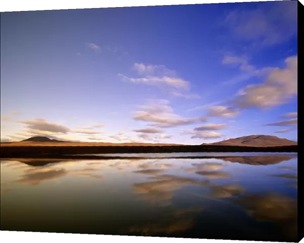 Canada, Yukon Territory, cumulus clouds reflected in Two Moose Lake in morning light