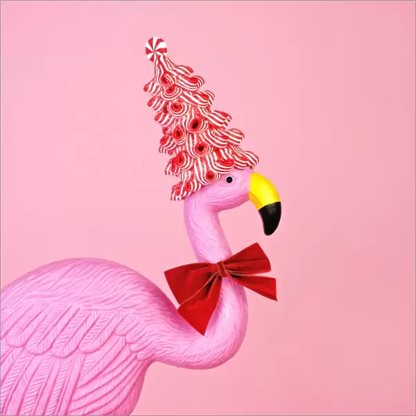 Pink flamingo wearing candy cane hat