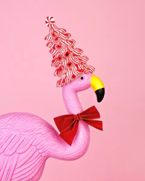 Pink flamingo wearing candy cane hat