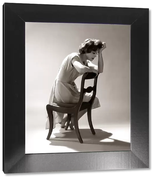 Depressed Sad Moody Woman Leaning Head Onto Arm Slouched Lean Back Of Chair Seated Depression Stress
