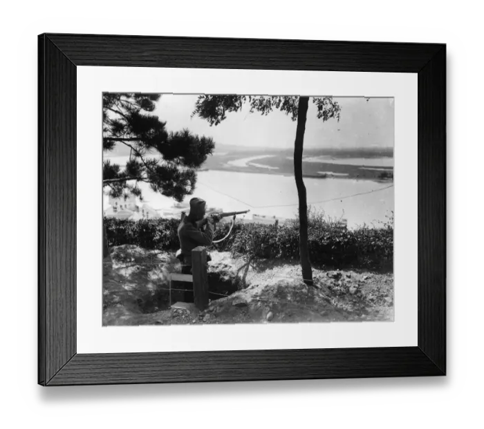 Framed Print : A Sniper. circa 1916: A sharpshooter aims over a river from high ground in Serbia