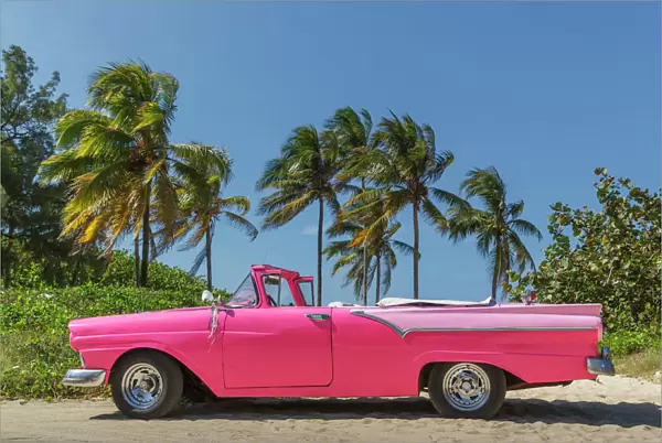 Pink vintage car on a cuban beach