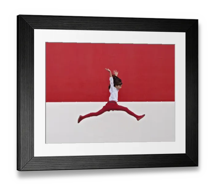Framed Print : Girl jumping in air at red wall Framed Print : Girl jumping in air at red wall
