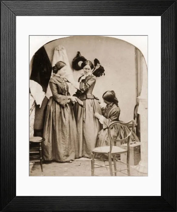 Framed Print : Tailoring. 1860: A woman kneeling to mend anothers skirt Framed Print : Tailoring. 1860: A woman kneeling to mend anothers skirt