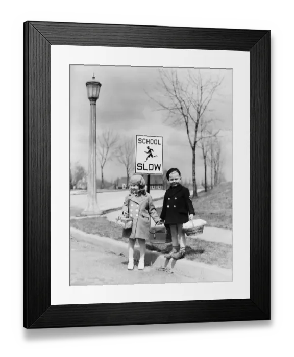 Framed Print : Boy and girl walking to school, about cross street by slow school sign Framed Print : Boy and girl walking to school, about cross street by slow school sign