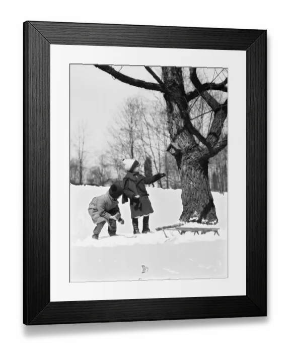 Framed Print : Two children pulling sled, looking up birdhouse in tree, winter Framed Print : Two children pulling sled, looking up birdhouse in tree, winter