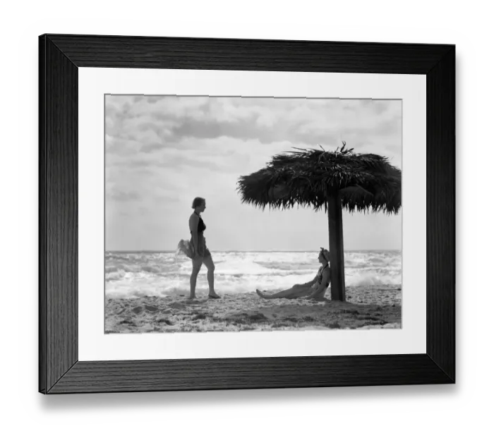 Framed Print : Two women under palm thatch umbrella on beach, Florida Framed Print : Two women under palm thatch umbrella on beach, Florida