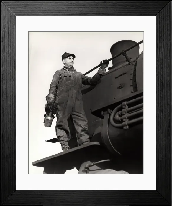 Framed Print : Man standing on train engine, holding oil can Framed Print : Man standing on train engine, holding oil can