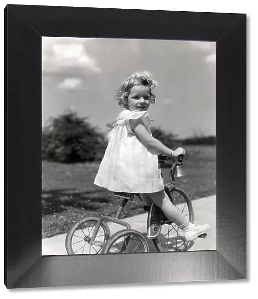 Girl wearing summer dress, riding tricycle down sidewalk. (Photo by H. Armstrong Roberts  /  Retrofile  /  Getty Images)