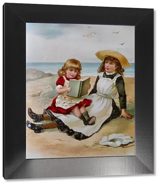 Two girls sitting on beach reading a book