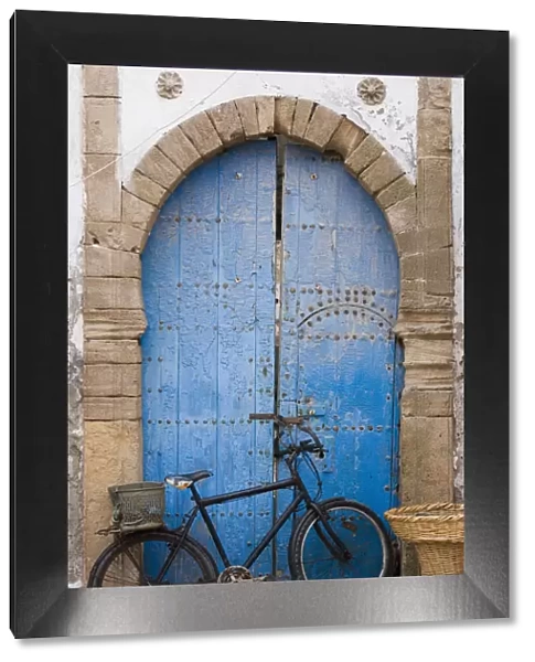 Morocco, Essaouira, bicycle propped against blue painted door