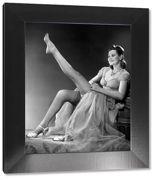 Woman in evening wear pullin on silk stockings