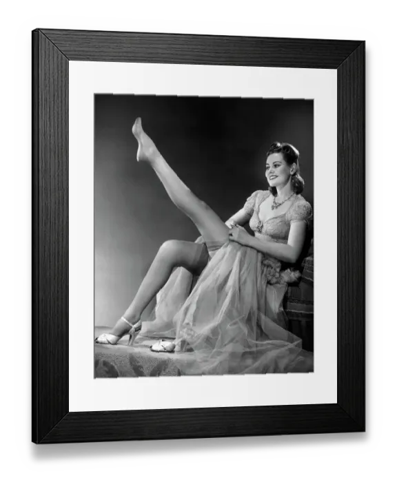 Framed Print : Woman in evening wear pullin on silk stockings Framed Print : Woman in evening wear pullin on silk stockings