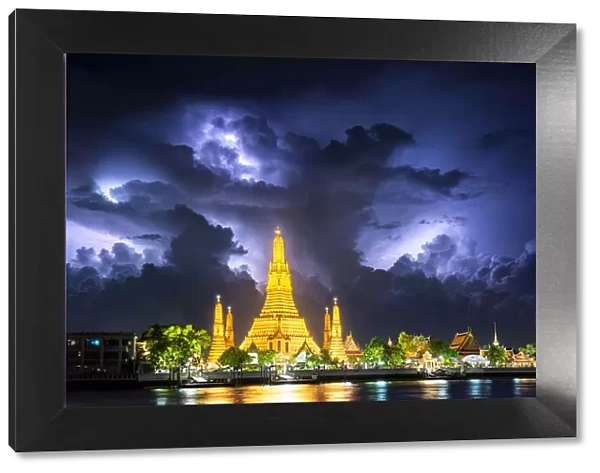 Lightning thunderstorm, rain, over Wat Arun, buddha temple famous landmark for travel by tourist on holiday in Bangkok city Thailand, Asia, after sunset time