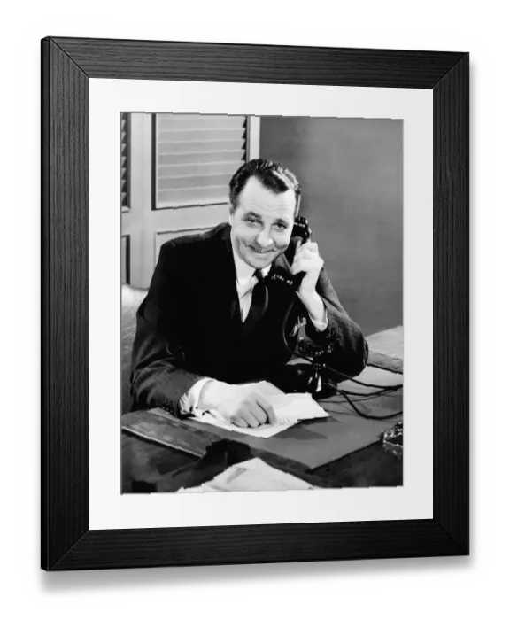 Framed Print : Businessman using telephone at his desk Framed Print : Businessman using telephone at his desk