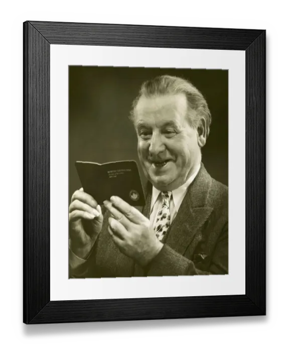 Framed Print : Mature man looking at a bank account booklet