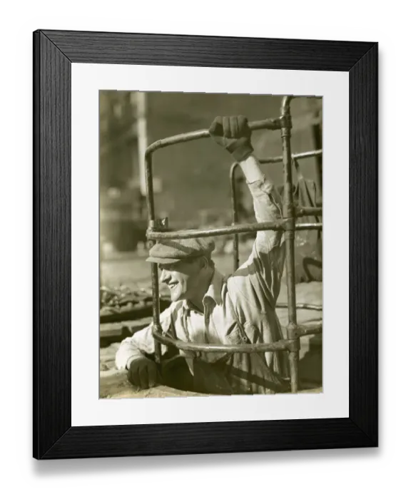 Framed Print : Sewer worker descending below street Framed Print : Sewer worker descending below street