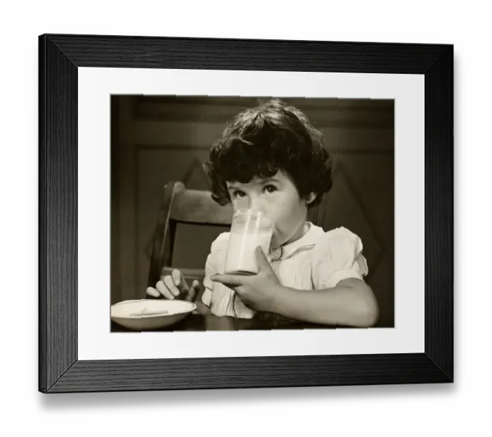 Framed Print : Little girl drinking a glass of milk at table Framed Print : Little girl drinking a glass of milk at table