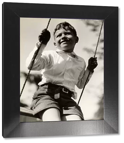 Boy in swing outdoors
