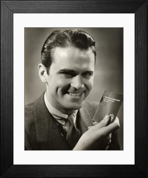 Framed Print : Close-up of smiling man with bank passbook Framed Print : Close-up of smiling man with bank passbook