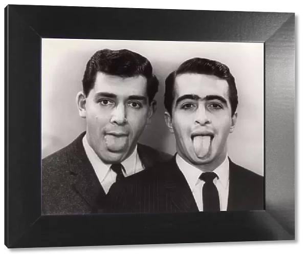 Close-up of two men with protruding tongues