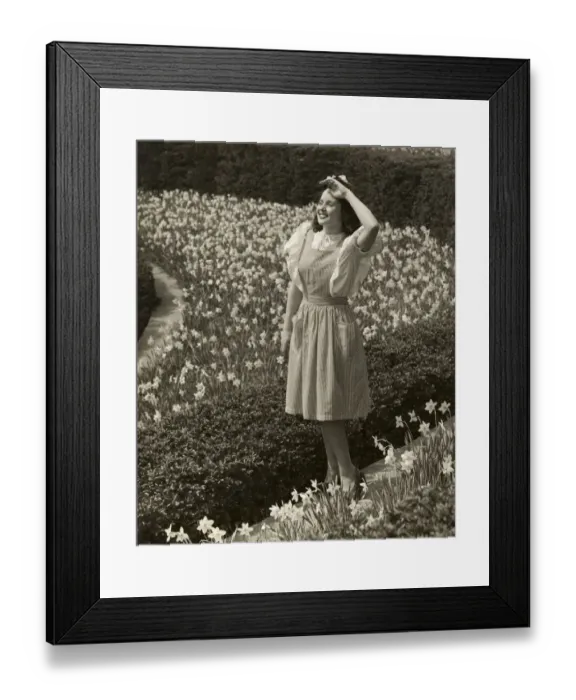 Framed Print : Woman standing among spring daffodils