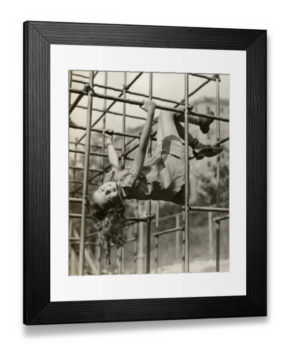 Framed Print : Child girl hanging upside down on jungle gym Framed Print : Child girl hanging upside down on jungle gym