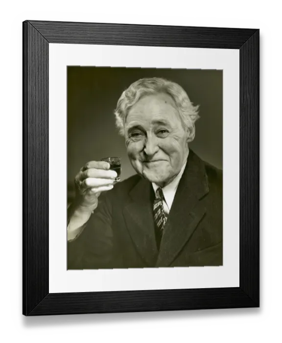 Framed Print : Elderly man raising glass of whiskey