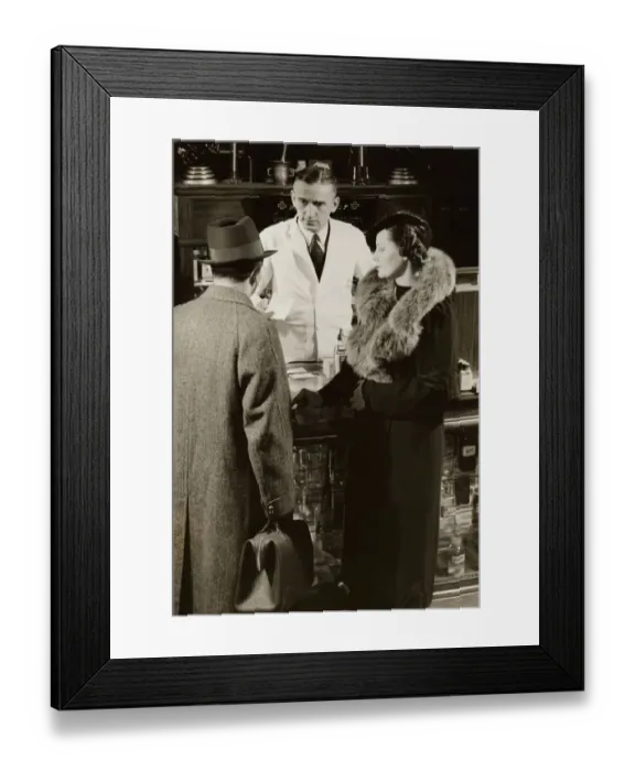 Framed Print : Pharmacist fills prescription for couple Framed Print : Pharmacist fills prescription for couple