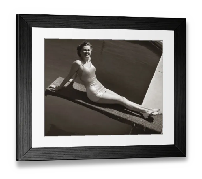 Framed Print : Woman in bathing suit sitting on diving board Framed Print : Woman in bathing suit sitting on diving board